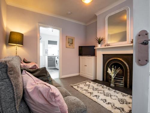 a living room with a couch and a fireplace at Central cosy home 5 minutes walk from Shrewsbury - Pass the Keys in Shrewsbury