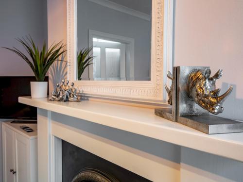 een open haard met een spiegel en een standbeeld erop bij Pass the Keys Central cosy home 5 minutes walk from Shrewsbury in Shrewsbury