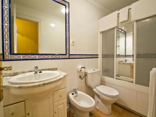 a bathroom with a sink and a toilet and a mirror at Apartamento EL RINCON DE MARIA in Santillana del Mar