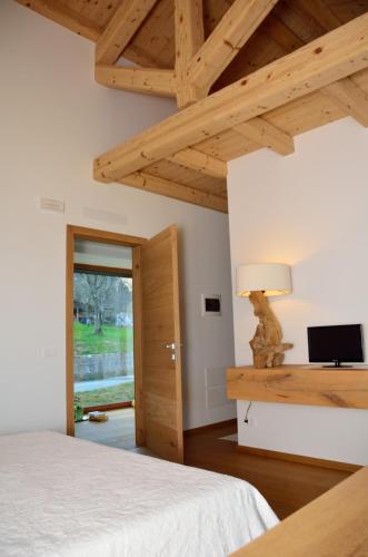 a bedroom with a bed and a table with a lamp at La casa di Maia - Alloggio Agrituristico in Pedavena