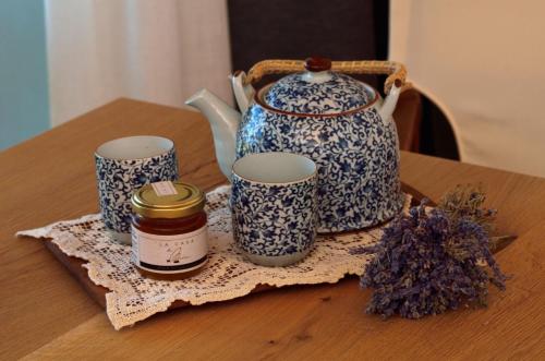 un tavolo con teiera, tre tazze e fiori secchi di La casa di Maia - Alloggio Agrituristico a Pedavena