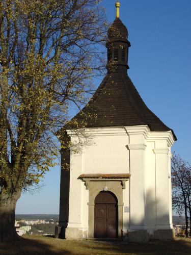 a small white building with a clock tower at Penzion pod Kostelíčkem in Třebíč
