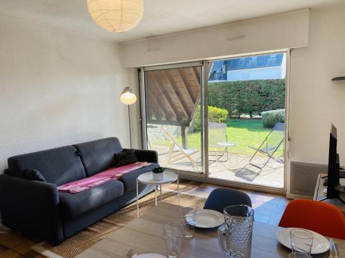 un salon avec un canapé noir et une table dans l'établissement PORT AN DRO 2 - Jardin, Wifi, Plage 450m - DT17, à Carnac