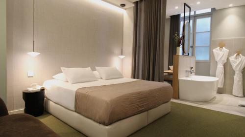a bedroom with a bed and a tub and a sink at MiHotel Sala in Lyon