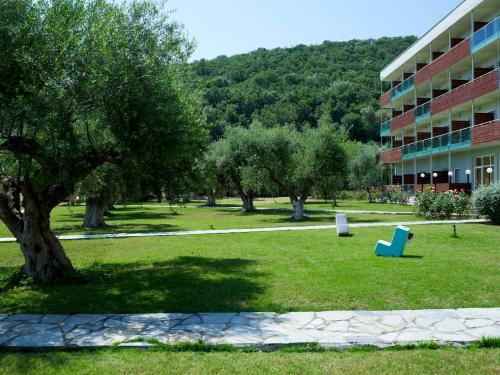 a park in front of a building with a tree at Belle Helene Hotel in Vathi, Mani