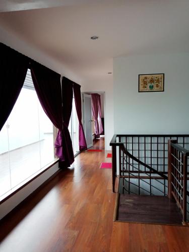 a living room with a staircase and a large window at Dear Dino Villa Cameron Highlands in Cameron Highlands