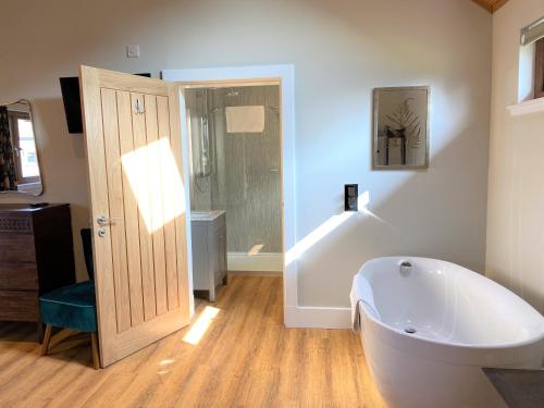 een badkamer met een bad, een toilet en een douche bij Partridge Lodge with Hot Tub in Forgandenny