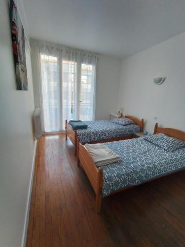 deux lits dans une chambre avec parquet dans l'établissement Echappée Belle à Montauban - garage, à Montauban