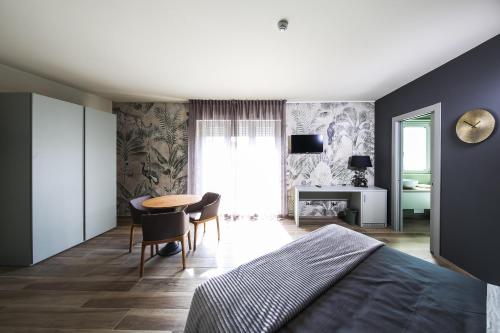 a bedroom with a bed and a table and chairs at Vicolo Malavolta 7 Rooms and Suites in Pedaso