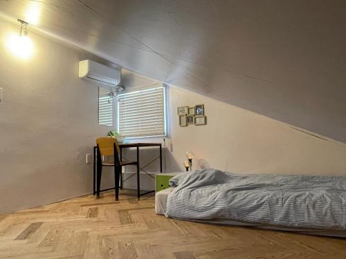 a bedroom with a bed and a table and a window at SISnBRO Guesthouse in Seoul