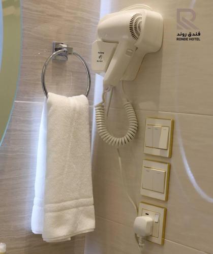 a phone hanging on a wall with a towel at فندق روند in Hafr Al Baten