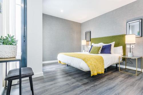 - une chambre avec un grand lit et une couverture jaune dans l'établissement Precioso Ático de diseño, gran Terraza y Garaje en pleno centro, à Séville