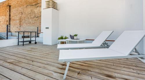 a room with white furniture and a wooden floor at Precioso Ático de diseño, gran Terraza de 35 m2 y de 16 m2 y Garaje en pleno Centro in Seville