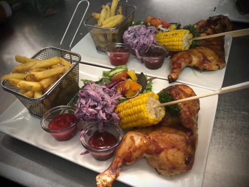 a plate of food with chicken and vegetables and french fries at The Punchbowl Inn in Woodstock