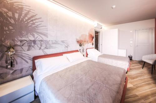 a bedroom with two beds and a wall with a mural at Vicolo Malavolta 7 Rooms and Suites in Pedaso