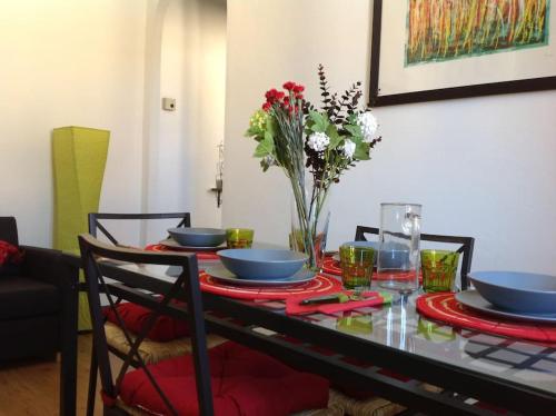 tavolo da pranzo con piatti blu e vaso di fiori di Nel cuore di Como a Como