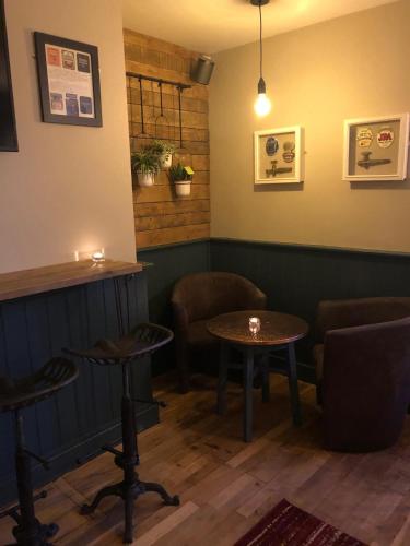 a bar with two tables and chairs in a room at The Punchbowl Inn in Woodstock