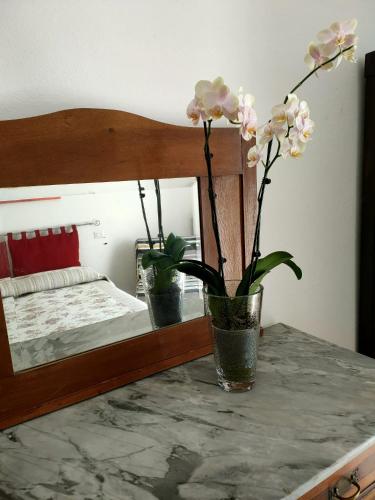 a table with a vase with flowers on it at La Rosa appartamenti in Monterchi