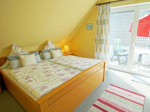 ein Schlafzimmer mit einem großen Bett und einem großen Fenster in der Unterkunft Haus Elke Wohnung 103 in Büsum