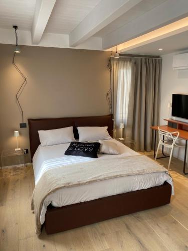 トッリ・デル・ベーナコにあるSuite Agli Archiの大きなベッドとテレビのある寝室