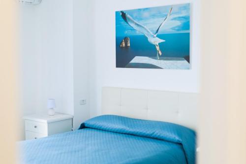 ein weißes Schlafzimmer mit einem Vogel, der über einem Bett fliegt in der Unterkunft Capri holiday home with a sea view in Capri