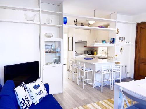 une cuisine avec des placards blancs et un canapé bleu dans l'établissement Caterina Apartment, à Portovenere