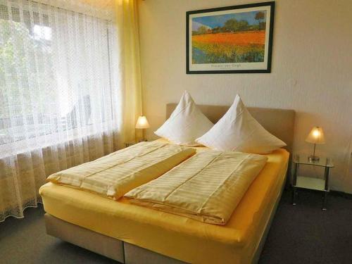 een slaapkamer met een bed met kussens en een raam bij Landhaus Sauerlandblick in Bestwig