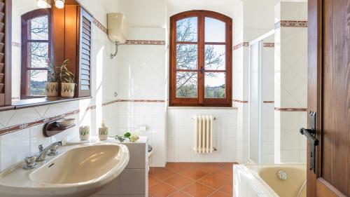 奧爾維耶托的住宿－CASALE LE TRE QUERCE 8&1, Emma Villas，一间带水槽和浴缸的浴室以及窗户。