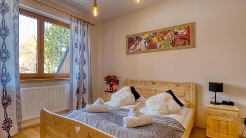 a bedroom with a bed with two pillows on it at Apartament Sywarne Deluxe in Kościelisko