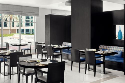 a dining room with tables and chairs in a restaurant at Holiday Inn Express Dubai Safa Park by IHG in Dubai