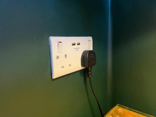 a phone is plugged into a wall in a room at Kirkwood Guest House in Windermere