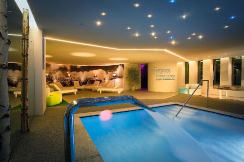a large swimming pool in a room with a house at Les Plaisirs d'Antan in Aosta