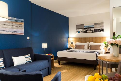 a hotel room with a bed and a couch at Citadines Croisette Cannes in Cannes