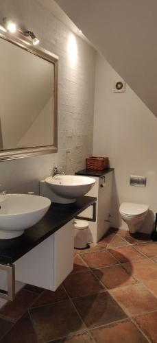 a bathroom with two sinks and a toilet at Østergård Kultur B&B in Læsø