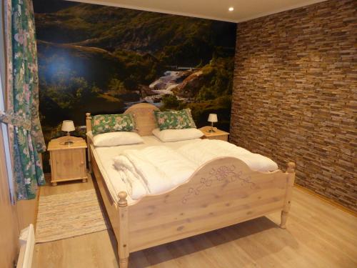 una camera da letto con un letto e un dipinto sul muro di Astabrygga a Sørvågen