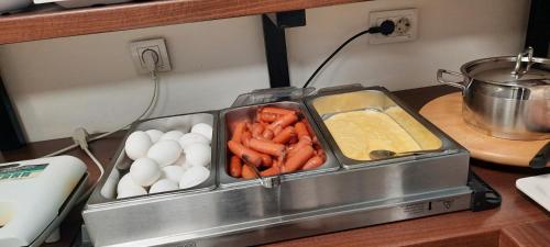 a tray of vegetables and eggs on a stove at Hotel DOA in Skopje