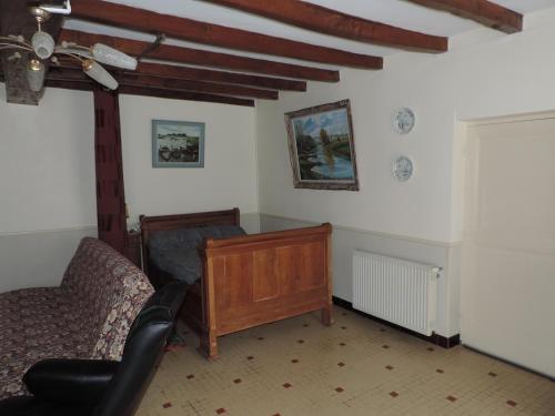 a living room with a bed and a chair at Gîte de l'Aubrée 17 in Puy-du-Lac