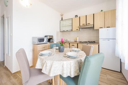 a kitchen and dining room with a table and chairs at Modern Oceanview in Metajna