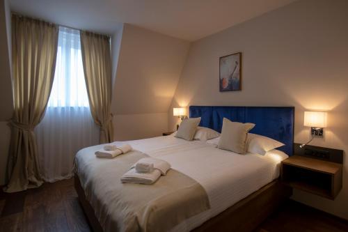 Resort Una Park في بيهاتش: غرفة نوم بسرير كبير عليها مناشف