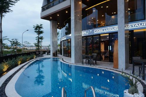 a swimming pool in front of a building at Mr. Boss House Apartment in Da Nang