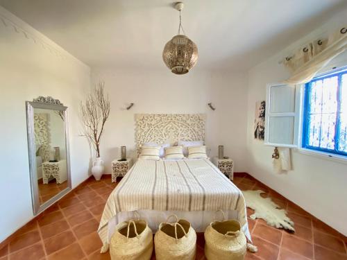 a bedroom with a bed with baskets on the floor at Villa Calma - Vue Mer in Al Ḩaddādah