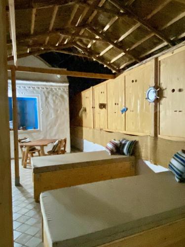 a room with two beds and a table and a clock at Villa Calma - Vue Mer in Al Ḩaddādah