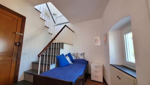 a bedroom with a bed and a staircase with blue pillows at L'Arpara Casa al Molo dal Mare al Castello in Lerici