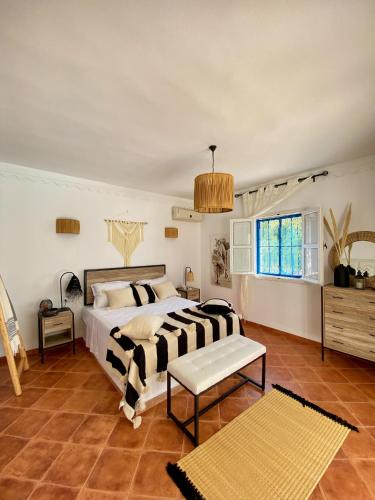 a bedroom with a black and white bed and a window at Villa Calma - Vue Mer in Al Ḩaddādah
