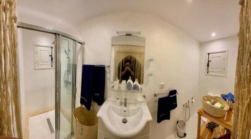 a bathroom with a sink and a shower at Villa Calma - Vue Mer in Al Ḩaddādah