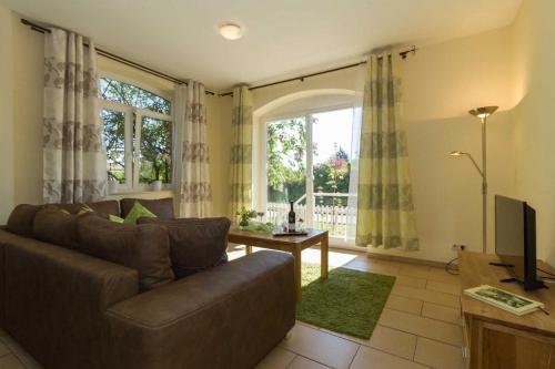 a living room with a couch and a television at Ostseeperlen-Haus 1 in Kühlungsborn