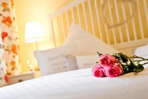 a bouquet of pink roses sitting on a bed at Ostseeperlen-Haus 1 in Kühlungsborn