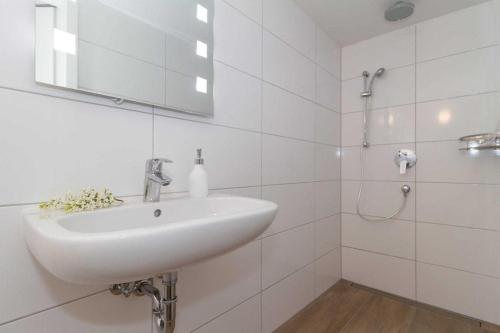 een witte badkamer met een wastafel en een douche bij Ostseeperlen-Haus 2 in Kühlungsborn