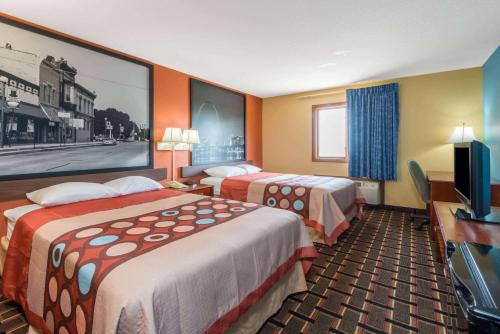 a hotel room with two beds and a flat screen tv at Super 8 by Wyndham Staunton in Staunton