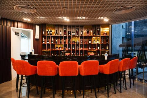 a bar with orange chairs in a restaurant at Cami Riverside Resort Da Nang in Da Nang